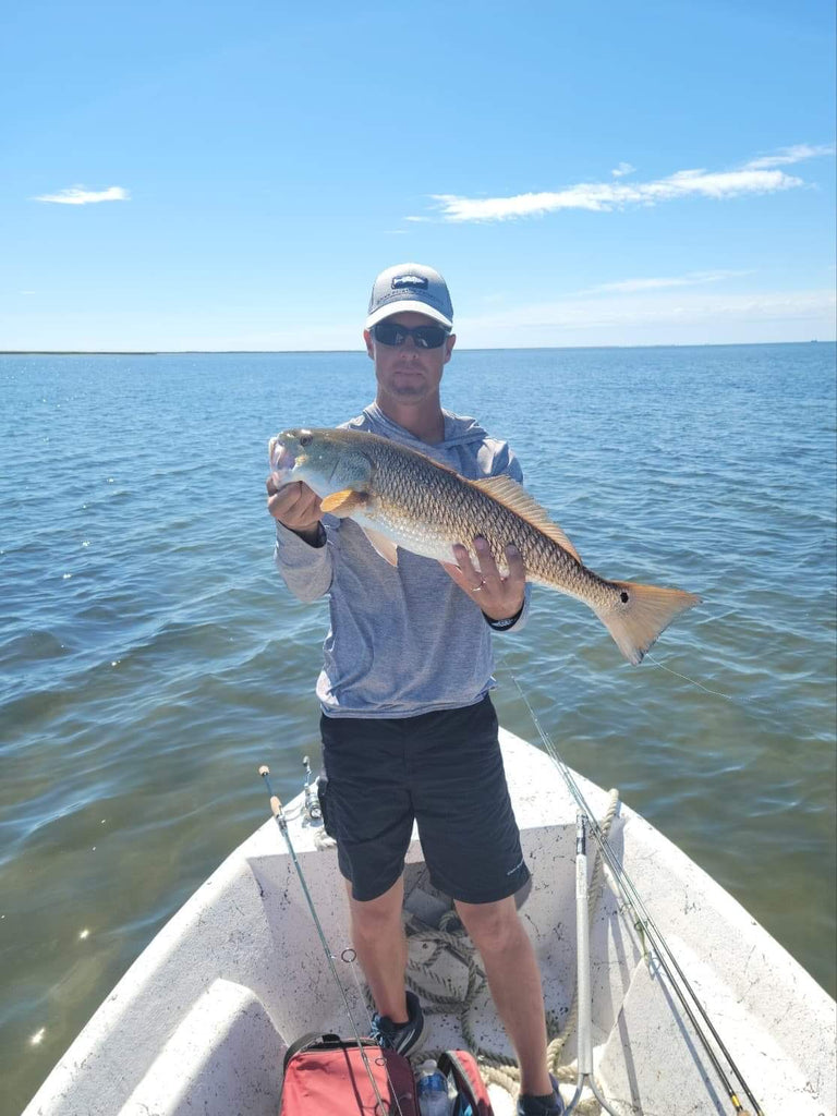 Best Chandeleur Islands Fishing Charter. Man holding up huge red fish at the Chandeleur Islands.