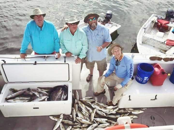 Men with coolers full of speckled trout at the Chandeleur Islands.