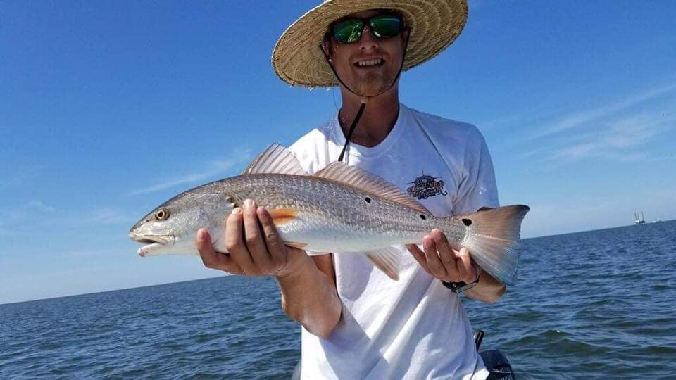 Man holding up huge speckled trout at the Chandeleur Islands.